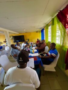 Njalla Quan Jnr discussing innovations with committee members and participants 